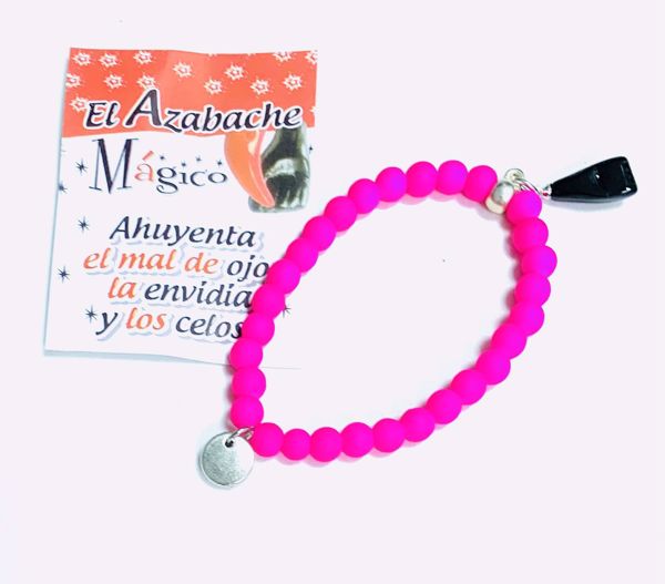 Imagen de Pulsera mano higa negra. Bolas de caucho rosa fucsia. Puño cerrado.